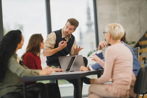 Marketing team gathered around a laptop during a workshop